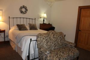 1 dormitorio con 1 cama y 1 silla en Maria's Creekside B&B, en Anchorage