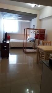 1 dormitorio con 1 cama y escritorio con TV en relajado monoambiente en San Miguel de Tucumán