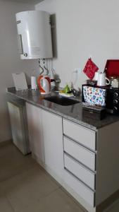 uma cozinha com um balcão com um lavatório em relajado monoambiente em San Miguel de Tucumán