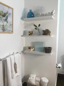 a bathroom with shelves with towels and stuffed animals at 2 bdr beach apartment, generator parking included in San Juan