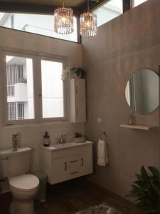 ein Badezimmer mit einem WC, einem Waschbecken und einem Spiegel in der Unterkunft 2 bdr beach apartment, generator parking included in San Juan