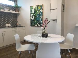 a white kitchen with a white table and chairs at 2 bdr beach apartment, generator parking included in San Juan