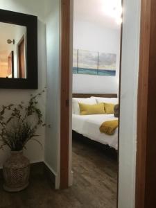 1 dormitorio con cama, espejo y planta en 2 bdr beach apartment, generator parking included, en San Juan