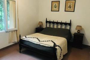 1 dormitorio con 1 cama negra y 2 mesitas de noche en Duplex en San Lorenzo, Salta en Salta