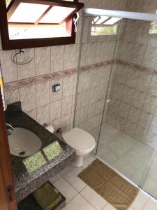 y baño con ducha, aseo y lavamanos. en Casa Canal Barra da Lagoa, en Florianópolis