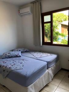 2 camas individuales en una habitación con ventana en Casa Canal Barra da Lagoa, en Florianópolis