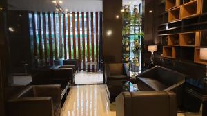 a waiting room with couches and stained glass windows at The Sriracha Residence in Si Racha