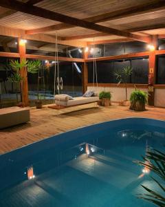 een groot zwembad in een huis met een schommel bij Fazenda Santa Rita Turismo Rural in Bom Jardim da Serra