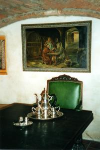 a table with a tea kettle and a painting on the wall at Haus am Markt in Königstein in der Oberpfalz