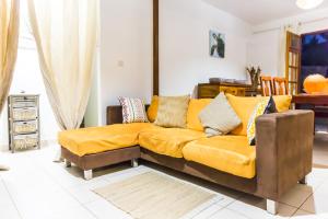 a living room with a couch with a yellow blanket at Villa A rabica - Extrait de Café in Pointe-Noire