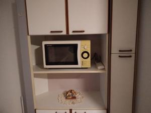 un microondas sentado en un estante en una cocina en Departamento en Loma Hermosa cercano a Palomar en Loma Hermosa