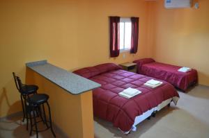 a room with a bed and a table and a counter at Suyana Departamentos in Tinogasta