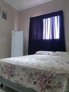 um quarto com uma cama e uma janela com uma cortina em Suítes Canaã em Canoa Quebrada
