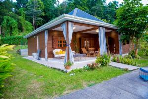 a small wooden cabin with a porch and a table at Villa A rabica - Extrait de Café in Pointe-Noire