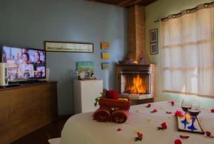a bedroom with a bed with roses on it with a fireplace at Pousada Bolo Húngaro in Visconde De Maua