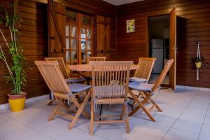 a wooden table and chairs on a patio at Villa A rabica - Extrait de Café in Pointe-Noire