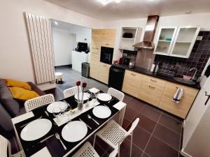 una cucina e una sala da pranzo con tavolo e sedie di Suite Barthelemy - Spa et Sauna a Melun