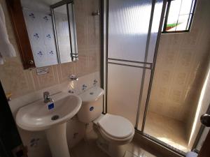 a bathroom with a toilet and a sink and a shower at Villa Apolonia in Guaduas