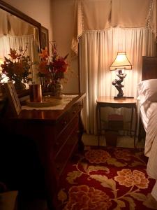 um quarto com uma cama e uma mesa com um candeeiro em WINNIE'S BED & BREAKFAST em Lawrenceburg