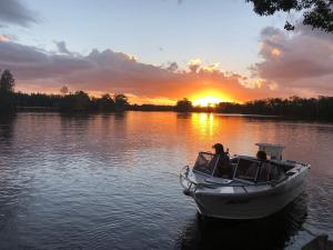 a group of people in a boat on a lake at sunset at Discovery Parks - Forster in Tuncurry