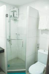 a bathroom with a glass shower with a toilet at Studio 89 Katipunan QC in Manila