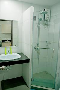 a bathroom with a glass shower and a sink at Studio 89 Katipunan QC in Manila