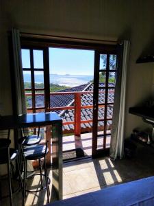 a room with a balcony with a view of the ocean at Burung Flats Itamambuca - Hospedagem com vista para o mar in Ubatuba