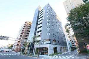 a tall building on the corner of a city street at S-peria Inn Nihombashi Hakozaki in Tokyo