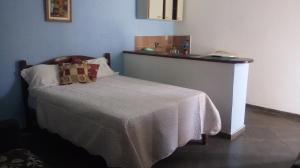 a bedroom with a bed with a table and a counter at Suites Americanas Em Jaconé in Jaconé