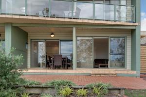 a house with glass doors and a patio at Discovery Parks - Forster in Tuncurry