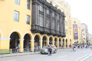 un'auto parcheggiata di fronte a un edificio giallo di Main Square a Lima