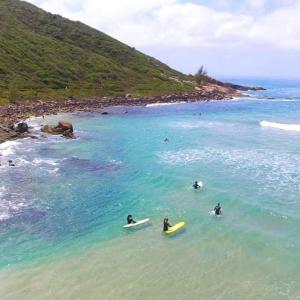 tre persone sono sdraiate su tavole da surf nell'oceano di Recanto Vó Terezinha a Imbituba Altre 7 foto