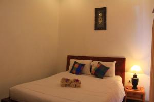 Un dormitorio con una cama con dos ositos de peluche. en Sila Urip Guest House, en Ubud