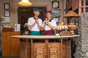 twee mannen die voor een toonbank staan te bidden bij Ketut's Place Bed & Breakfast Ubud in Ubud