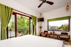 会安AnBang Morning Glory Beach Homestay 호이안 안방비치 숙소호텔的一间卧室，里面有一张床和一扇大窗户。