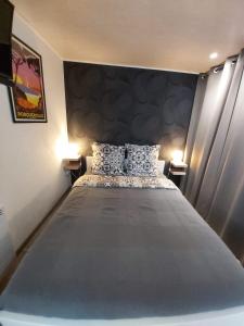 ein großes Bett in einem Zimmer mit zwei Lampen in der Unterkunft STUDIO VILLA NUI in Cuers