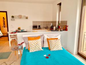 1 dormitorio con 1 cama azul con almohadas y cocina en Sunny Deluxe Apt. & Terrace, en Budapest