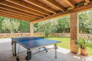 una mesa de ping pong en un patio bajo un techo de madera en Can Pedro en Ariany