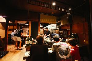 a group of people in a kitchen preparing food at Town Guide Hotel nirasakiyaSTAY in Nirasaki