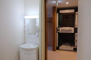 a bathroom with a sink and a toilet and a mirror at 大田市ゲストハウス 雪見院 Guesthouse Yukimi-inn in Ōda