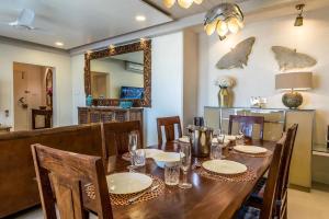 ein Esszimmer mit einem Tisch mit Stühlen und einem Spiegel in der Unterkunft Families & Corporates 3-Bed Apt, Fashion Res, Pune in Pune