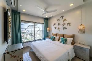 ein Schlafzimmer mit einem Bett mit Vögeln an der Wand in der Unterkunft Families & Corporates 3-Bed Apt, Fashion Res, Pune in Pune + 40 Fotos
