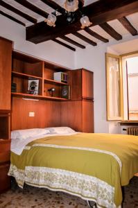 a bedroom with a large bed with a wooden headboard at Appartamento Gubbio Vacanze in Gubbio