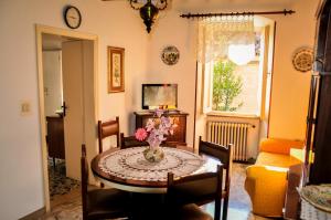 a room with a table with a vase of flowers on it at Appartamento Gubbio Vacanze in Gubbio