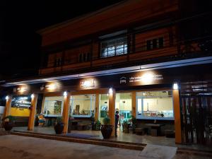 una tienda frente a un edificio por la noche en Zone Stations -That Phanom en That Phanom