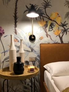 ein Schlafzimmer mit einem Tisch mit Vasen und einer Lampe in der Unterkunft Residence Relais Cà dell'Era in Tremosine sul Garda