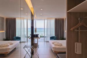 a hotel room with two beds and a view of the ocean at Posia Retreat & Spa UNA Esperienze in San Foca