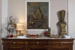 La Dimora Dei Monaci في سيينا: طاولة عليها طعام مع لوحة على الحائط