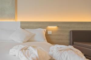 a bedroom with a bed with white sheets and pillows at Posia Retreat & Spa UNA Esperienze in San Foca