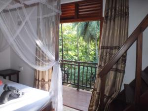una camera con letto e un balcone con finestra di Abraham Beach House a Tangalle